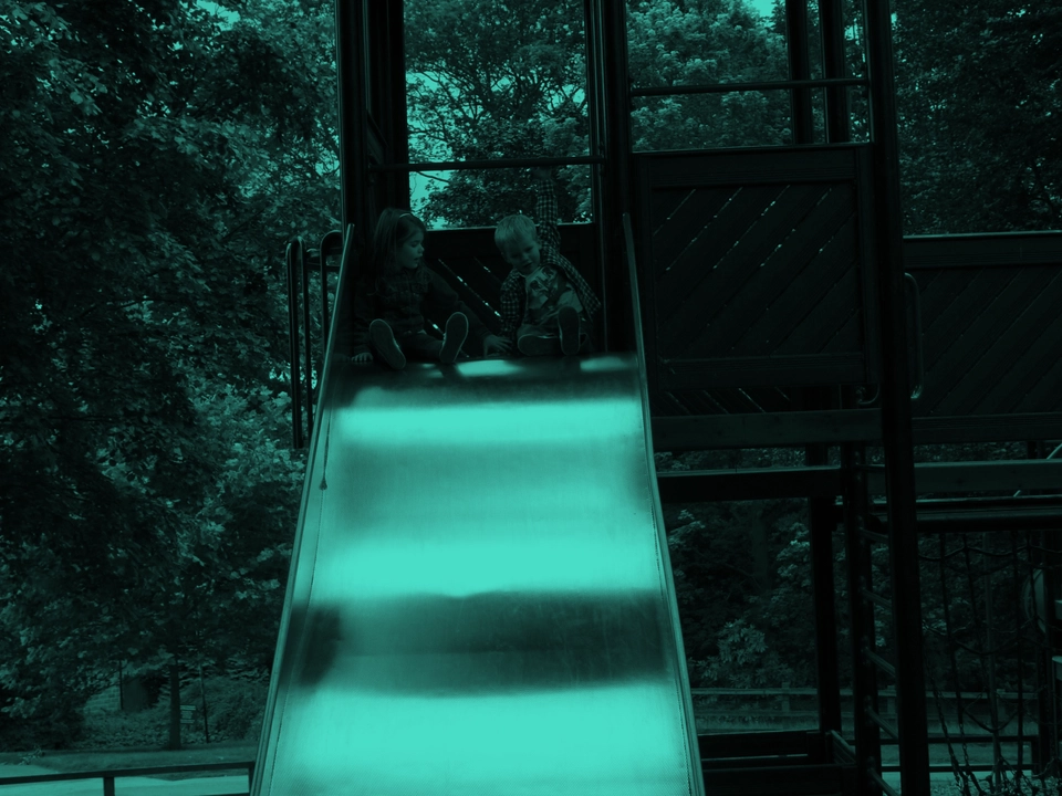 At the top of a slide in a park.